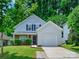 Charming two-story home with well-manicured lawn, garage, and a welcoming facade with lush green trees at 3830 Brookchase Ln, Charlotte, NC 28205