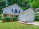 Charming two-story home with well-manicured lawn, garage, and a welcoming facade with lush green trees at 3830 Brookchase Ln, Charlotte, NC 28205