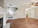 Cozy living room features a fireplace, wood flooring, and a staircase leading to the upper level at 3830 Brookchase Ln, Charlotte, NC 28205