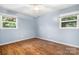 Bedroom with hardwood floors, ceiling fan, and dual windows providing ample natural light at 408 Kennerly Dr, Indian Trail, NC 28079