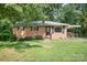 Charming single-story brick home with black shutters, a pergola, and a well-maintained lawn at 408 Kennerly Dr, Indian Trail, NC 28079