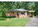 Traditional brick home featuring a cozy front porch and a well-manicured lawn at 408 Kennerly Dr, Indian Trail, NC 28079