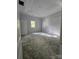 A serene bedroom featuring plush gray carpeting, a tray ceiling, and natural light from a large window at 409 Everette St, Monroe, NC 28112