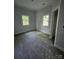 Bright bedroom with plush gray carpeting, two windows for natural light, and neutral walls at 409 Everette St, Monroe, NC 28112
