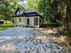 Stylish home with a metal roof, covered porch, and a spacious driveway surrounded by greenery at 409 Everette St, Monroe, NC 28112