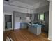 Kitchen with modern gray cabinets, an island, and elegant backsplash, seamlessly flowing into the living space at 409 Everette St, Monroe, NC 28112