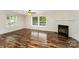 Inviting living room with a cozy fireplace, expansive windows, and stylish laminate flooring, creating a warm atmosphere at 508 Bridgestone Ln, Rock Hill, SC 29730