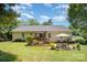 Beautifully landscaped backyard with lush green grass, patio area, and mature trees for relaxation at 551 Sand Trap Dr, York, SC 29745