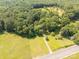 Aerial view of a property showcasing its serene setting amidst lush greenery and nearby fields at 6115 Campbell Rd, York, SC 29745