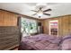 Spacious bedroom featuring wood-paneled walls, a ceiling fan, and a comfortable queen-sized bed at 6115 Campbell Rd, York, SC 29745