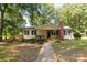Charming single-story home with inviting front porch, brick chimney, and walkway, surrounded by mature trees at 6115 Campbell Rd, York, SC 29745