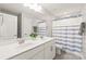 Bathroom featuring double sinks, a white and blue striped shower curtain, and white cabinets at 6320 Tilley Way, Matthews, NC 28105