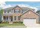 Charming two-story brick home with a manicured lawn and attached two-car garage at 6320 Tilley Way, Matthews, NC 28105