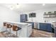 Kitchen island with bar seating and a sink overlooking the stainless steel dishwasher and dark blue cabinetry at 6320 Tilley Way, Matthews, NC 28105