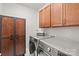 Well organized laundry room with wooden cabinets and modern washer and dryer at 6320 Tilley Way, Matthews, NC 28105