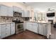 Well-lit kitchen with stainless steel appliances, granite countertops, and modern cabinetry and a living area in the background at 6422 Gatesville Ln, Charlotte, NC 28270