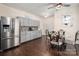 Bright eat-in kitchen with stainless steel refrigerator, wooden table, and view of pantry cabinets with decorative backsplash at 6422 Gatesville Ln, Charlotte, NC 28270