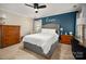 Primary bedroom featuring a king bed, accent wall, nightstands, and dresser offering comfort and style at 6422 Gatesville Ln, Charlotte, NC 28270