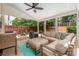 Covered patio with outdoor seating, including a cozy sectional, an ottoman, and a ceiling fan at 6422 Gatesville Ln, Charlotte, NC 28270