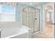 Bathroom featuring glass-enclosed shower and soaking tub under a window at 809 Ayrshire Ave, Fort Mill, SC 29708