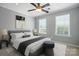 Comfortable bedroom features soft gray walls, two windows, a ceiling fan, and a stylish gray upholstered bed at 809 Ayrshire Ave, Fort Mill, SC 29708