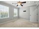 Bedroom with neutral walls and carpet features a ceiling fan, large window, and walk in closet at 809 Ayrshire Ave, Fort Mill, SC 29708
