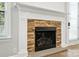 Close-up of a modern stone fireplace with a white mantel, hardwood floors, and natural light at 809 Ayrshire Ave, Fort Mill, SC 29708
