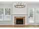 Modern fireplace with stone surround, white mantel, and two windows on either side in a bright living room at 809 Ayrshire Ave, Fort Mill, SC 29708