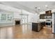 Open-concept living room and kitchen area featuring hardwood floors, fireplace, and modern island at 809 Ayrshire Ave, Fort Mill, SC 29708