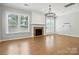 Bright living room features large windows, hardwood floors, a stone fireplace, and modern light fixture at 809 Ayrshire Ave, Fort Mill, SC 29708