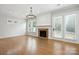Bright living room featuring hardwood floors, stone fireplace, large windows and a glass panel door at 809 Ayrshire Ave, Fort Mill, SC 29708