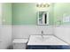 Bright bathroom with white wainscoting, mint green paint, and a navy vanity at 814 W Gold St, Kings Mountain, NC 28086