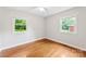 Bedroom with hardwood floors and two windows overlooking the green backyard at 814 W Gold St, Kings Mountain, NC 28086