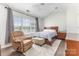Bedroom with wood-look flooring, a bed near the window, and a recliner at 9720 Walkers Glen Nw Dr, Concord, NC 28027