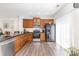 Well-lit kitchen features wood cabinets, stainless steel appliances, and dark countertops at 9720 Walkers Glen Nw Dr, Concord, NC 28027