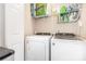 This is the laundry room with white washer and dryer units, shelves and a white door at 9720 Walkers Glen Nw Dr, Concord, NC 28027