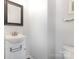 Simple powder room with white vanity, white walls, and dark mirror frame at 9720 Walkers Glen Nw Dr, Concord, NC 28027