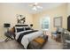 Stylish main bedroom featuring a modern bed, accent chair, and ample natural light, creating a relaxing and elegant space at 975 Pine Knoll Rd, Fort Mill, SC 29715