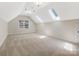 Spacious bonus room with skylights, a large window, and neutral-toned carpeting at 10333 Scott Gate Ct, Charlotte, NC 28277