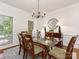 Elegant dining room with a glass-top table, stylish chandelier, and large windows at 10333 Scott Gate Ct, Charlotte, NC 28277