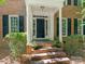 Inviting front porch with brick steps, white columns, and a stylish black front door at 10333 Scott Gate Ct, Charlotte, NC 28277