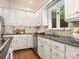 Well-lit kitchen features stone backsplash, dark counters, and white cabinets at 10333 Scott Gate Ct, Charlotte, NC 28277