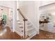 Carpeted staircase with a wood handrail leading to the upper level and a view of the office at 10333 Scott Gate Ct, Charlotte, NC 28277