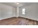 Empty bedroom with hardwood floors, white walls, window and a door to the closet at 104 W Maryland Ave, Bessemer City, NC 28016