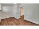 Empty bedroom featuring hardwood floors, white walls, and a bathroom door at 104 W Maryland Ave, Bessemer City, NC 28016