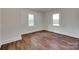 Empty bedroom with hardwood floors, white walls, and two windows for plenty of natural light at 104 W Maryland Ave, Bessemer City, NC 28016
