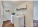 Practical laundry room with modern washer and dryer units and shelving at 104 W Maryland Ave, Bessemer City, NC 28016