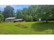 Rustic barn on a sprawling green lot, surrounded by lush trees and foliage, creates a picturesque country setting at 11056 Us Highway 52 N Hwy, Wadesboro, NC 28170