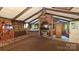 Cozy living room showcasing a striking brick fireplace, wood paneling, and exposed beams, creating a warm ambiance at 11056 Us Highway 52 N Hwy, Wadesboro, NC 28170