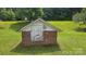 A small brick outbuilding features white painted trim and a shingled roof in the yard at 11056 Us Highway 52 N Hwy, Wadesboro, NC 28170